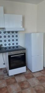 a kitchen with a stove top oven next to a refrigerator at 3pièces stade de France Grand-Paris in Saint-Denis
