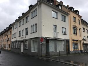un bâtiment blanc dans une rue avec un panneau d'arrêt dans l'établissement MacFeWo - Komplette Ferienwohnung im Stadtkern von Mayen, à Mayen