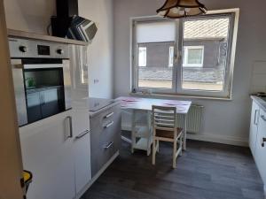 une cuisine avec une petite table et une fenêtre dans l'établissement MacFeWo - Komplette Ferienwohnung im Stadtkern von Mayen, à Mayen
