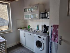 une cuisine avec un évier et une machine à laver dans l'établissement MacFeWo - Komplette Ferienwohnung im Stadtkern von Mayen, à Mayen 6 autres photos