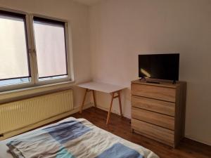 une chambre avec un lit et une télévision sur une commode dans l'établissement MacFeWo - Komplette Ferienwohnung im Stadtkern von Mayen, à Mayen