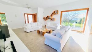 una sala de estar con 2 sofás blancos y una mesa. en Villa Boutique ibiza, en Santa Eulària des Riu