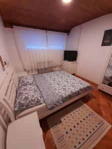 Kleines Zimmer mit einem Bett und einem TV in der Unterkunft Kuća za odmor Jovanović in Perućac
