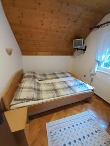 een bed in een kamer met een houten plafond bij Kuća za odmor Jovanović in Perućac