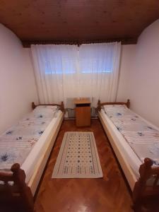 two beds in a room with a window at Kuća za odmor Jovanović in Perućac