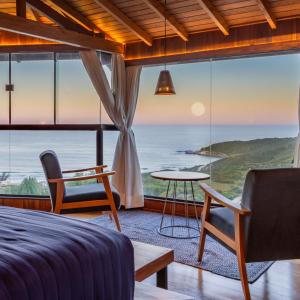 1 dormitorio con cama y vistas al océano en Pousada Caminho do Rei, en Praia do Rosa