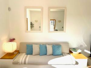 a living room with a couch with two mirrors at Villa Sant'Anna - Pescoluse in Salve