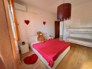 un orsacchiotto seduto su un letto in una camera da letto di Lovely apartment a due passi dal mare a Rimini