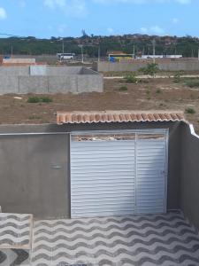 un garaje con una puerta en el lateral de un edificio en Casa de praia majorlandia, en Majorlândia