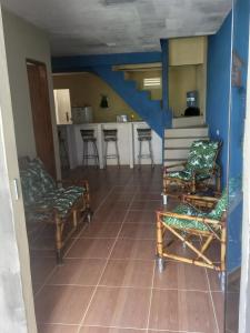 a living room with chairs and a kitchen at Casa de praia majorlandia in Majorlândia