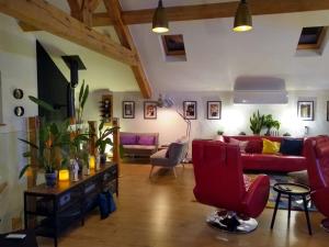 a living room with a red couch and chairs at Country Escape at the Granary in Colchester