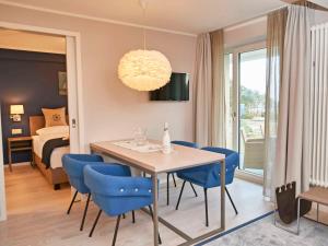 una sala da pranzo con tavolo e sedie blu di Strandresort Prora - WG 202 mit Meerblick und Sauna a Binz