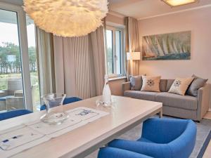 sala de estar con mesa y sillas azules en Strandresort Prora - WG 202 mit Meerblick und Sauna, en Binz