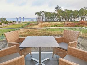 una mesa y sillas en un balcón con vistas al océano en Strandresort Prora - WG 202 mit Meerblick und Sauna, en Binz