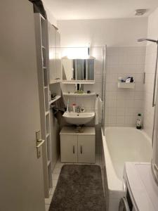 a bathroom with a sink and a tub and a toilet and a sink at Die Feelgood-Wohnung am Mondsee in Mondsee