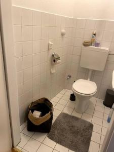 a bathroom with a toilet and a trash can at Die Feelgood-Wohnung am Mondsee in Mondsee
