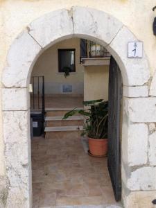 un ingresso a un edificio con arco in pietra di Casa Largo Chiesa a Fornelli