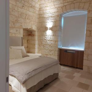 1 dormitorio con cama y pared de ladrillo en Palazzo Momi en Bari