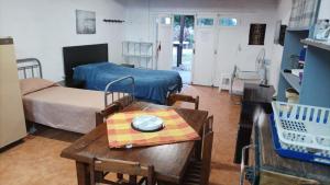 sala de estar con mesa y habitación con cama en Las Hortensias Monoambiente, en La Pedrera