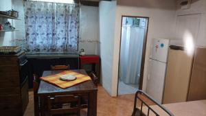 een kleine keuken met een tafel en een koelkast bij Las Hortensias Monoambiente in La Pedrera