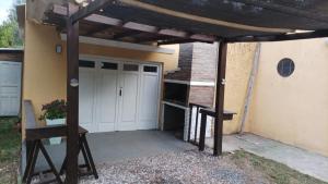 garaje con puerta blanca y pérgola de madera en Las Hortensias Monoambiente, en La Pedrera