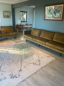 sala de estar con sofás y mesa de cristal en La maison des Rimains, en Cancale