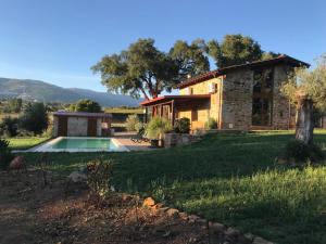una casa in pietra con piscina in un cortile di Quinta Lourena - Casa do Desassossego a Covilhã