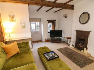 un soggiorno con divano e camino di Courtyard Cottage a Kirkby Lonsdale