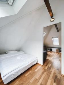 a bedroom with a white bed and a wooden floor at Dinbnb Apartments I Loft I Easy check-in in Bergen