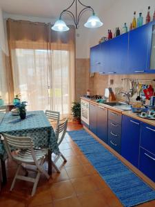 a kitchen with blue cabinets and a table with chairs at La Casa del Sole in Giarre