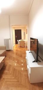 un soggiorno con TV su un pavimento in legno di Modern home, 6' from the Metro ad Atene