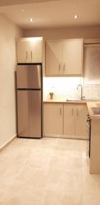 a kitchen with a refrigerator and white cabinets at Modern home, 6' from the Metro in Athens