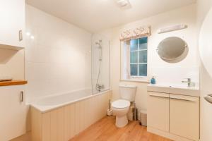 a bathroom with a toilet and a tub and a sink at Broads Reach - Norfolk Holiday Properties in Stalham