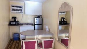 a small kitchen with a table and a mirror at Royal Palace Inn and Suites Myrtle Beach Ocean Blvd in Myrtle Beach