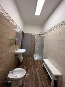 La salle de bains est pourvue d'un lavabo, de toilettes et d'une douche. dans l'établissement Comeacasatua 2.0, à Bari