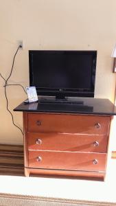 a tv on top of a dresser with a television on it at Royal Palace Inn and Suites Myrtle Beach Ocean Blvd in Myrtle Beach
