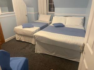 2 camas individuales en una habitación pequeña con puerta en Kinsale B&B en Scilly