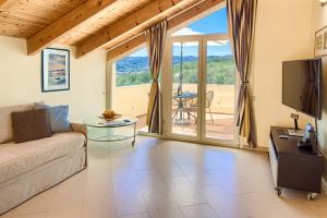 ディアーノ・マリーナにあるAppartamenti Villa il Poggioloのソファとテレビのあるリビングルーム