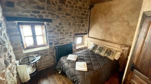 1 dormitorio con cama y pared de piedra en Elpajardeportilla, en León