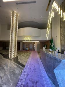 a lobby with a purple floor and chandeliers at Golden New Quraish Jeddah in Jeddah
