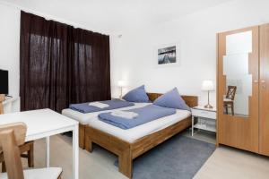 a bedroom with two beds and a table and a mirror at Pension Genat in Wedemark
