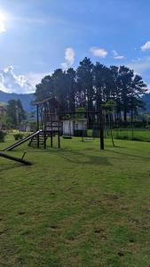 a park with a playground with trees in the background at Loft Sahy - Condado Aldeia dos Reis in Mangaratiba
