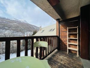 a balcony with a table and a chair and mountains at Studio Montagne - Plein Soleil et Terrasse in Briançon