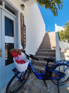 una bicicletta parcheggiata davanti a una porta con un cestino di Agnanti Hotel ad Adámas