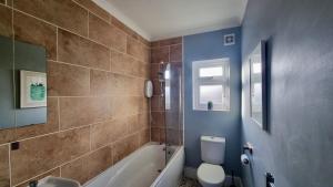 a bathroom with a tub and a toilet and a sink at The Loft by Switchback Stays in Cardiff +18 photos