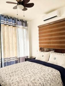 - une chambre avec un lit et un ventilateur de plafond dans l'établissement The Nova Scotia Resort Botolan, à Binuclutan