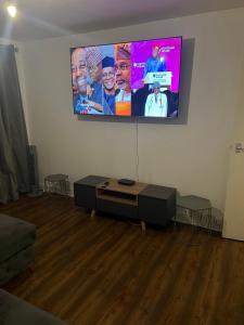 ein Wohnzimmer mit einem Flachbild-TV an der Wand in der Unterkunft Accu care apartment in London