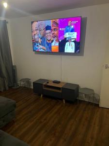 a living room with a flat screen tv on a wall at Accu care apartment in London