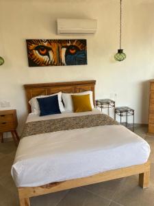 a bedroom with a large bed with a painting on the wall at Private villa, pool with ocean view and sounds in Puerto Vallarta