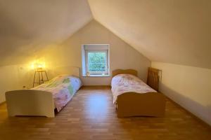 a attic bedroom with two beds and a window at Gîte dû Raddon in Raddon-et-Chapendu